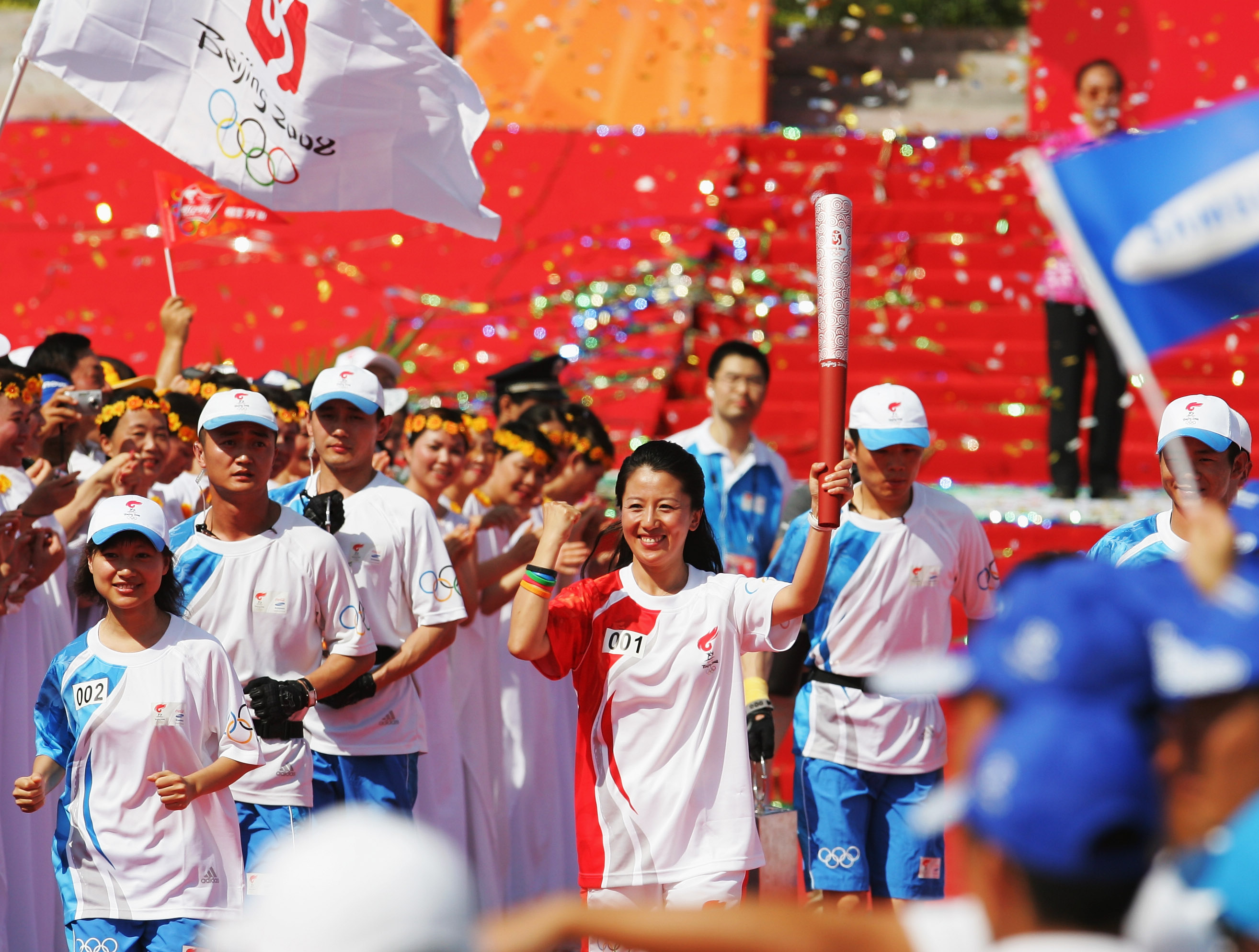 Une femme arrive avec la torche olympique