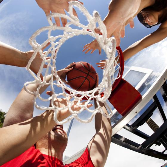 Vue en contre plongée de joueurs allant marquer un panier au basket 