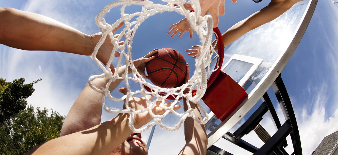 Vue en contre plongée de joueurs allant marquer un panier au basket 