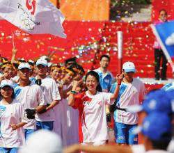 Une femme arrive avec la torche olympique