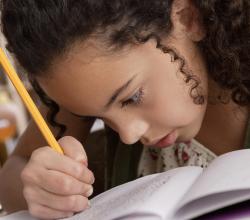 Photo d'une enfant écrivaznt en classe.